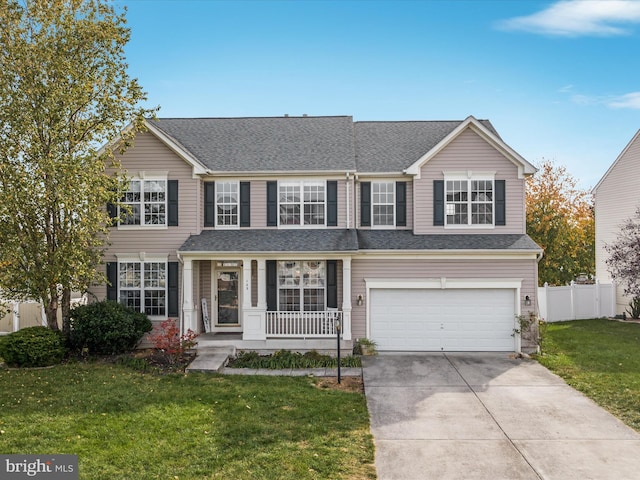 view of front of property featuring a garage, a front yard, and a porch