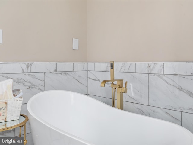 bathroom featuring tile walls and a bathing tub