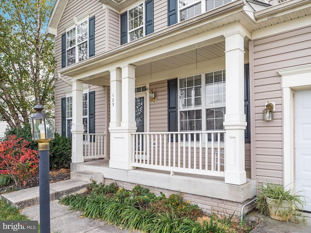 doorway to property featuring a garage and a porch