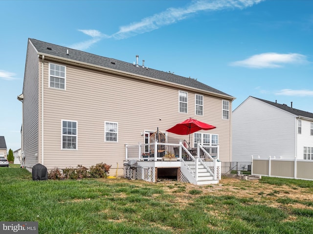 rear view of property featuring a lawn and a wooden deck