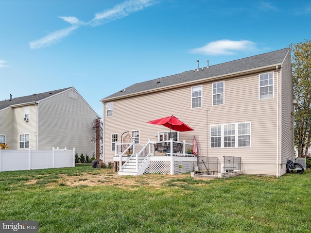 rear view of house featuring a yard and a deck