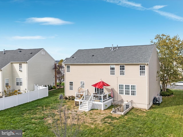 rear view of house with a yard and a deck