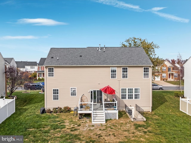 rear view of property featuring a yard and a deck