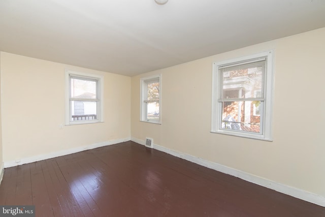 unfurnished room with dark hardwood / wood-style flooring