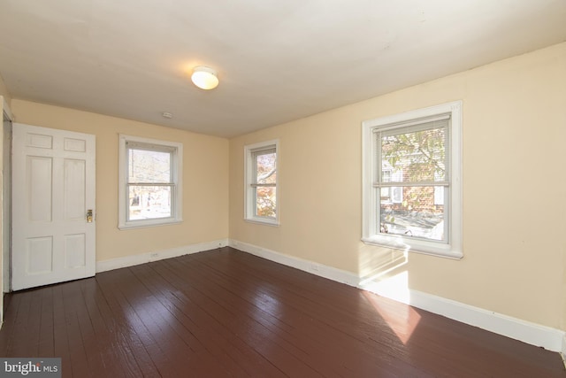 empty room with dark hardwood / wood-style flooring