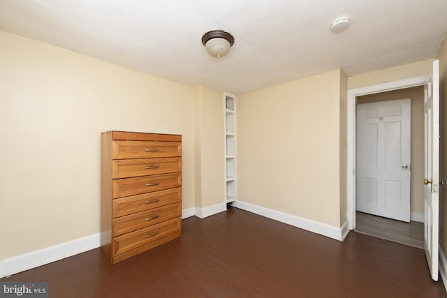 unfurnished bedroom with dark hardwood / wood-style flooring