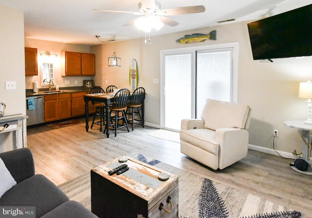 living room with ceiling fan, sink, and light hardwood / wood-style flooring