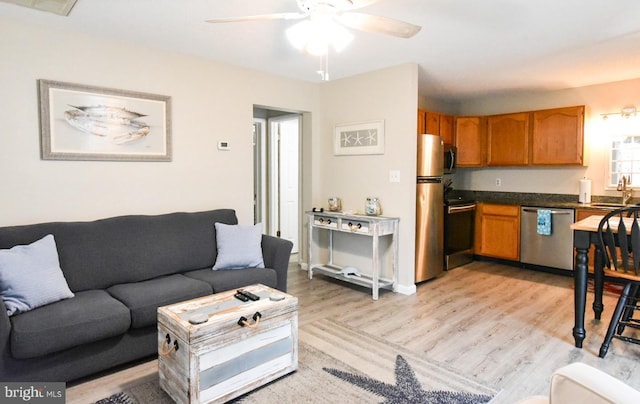 living room featuring light hardwood / wood-style floors, ceiling fan, and sink