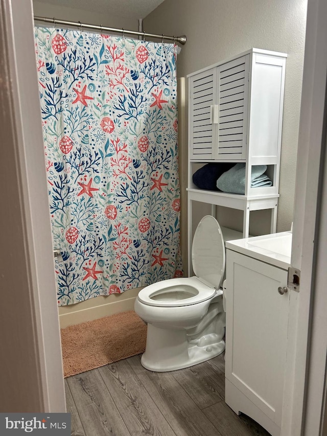 full bathroom with vanity, hardwood / wood-style flooring, toilet, and shower / tub combo with curtain