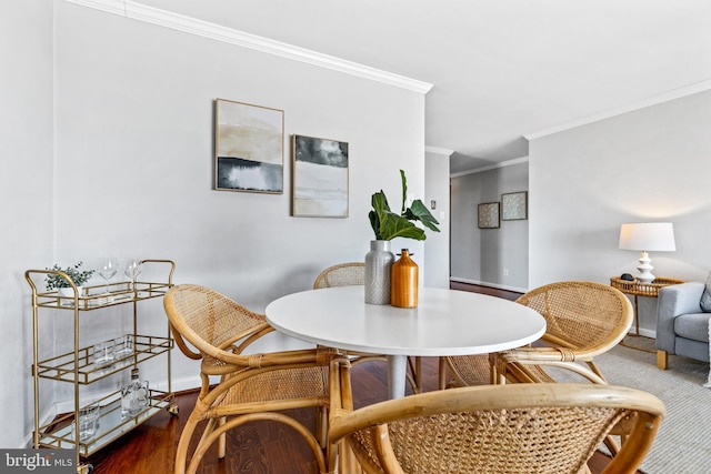 dining area with ornamental molding and hardwood / wood-style floors