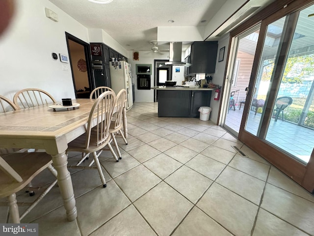 tiled dining area featuring a textured ceiling and ceiling fan