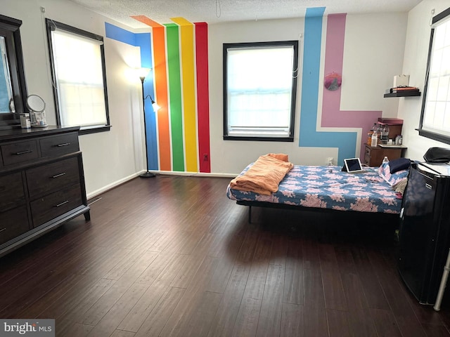 bedroom with dark hardwood / wood-style floors and a textured ceiling