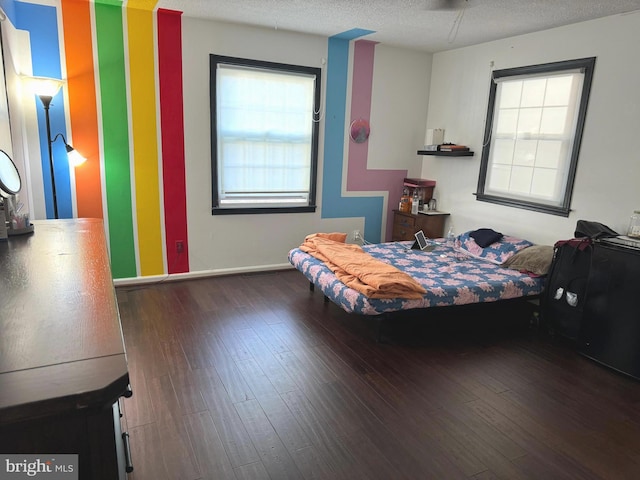 bedroom with dark wood-type flooring, multiple windows, and a textured ceiling