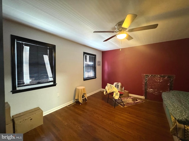 sitting room with dark hardwood / wood-style flooring and ceiling fan