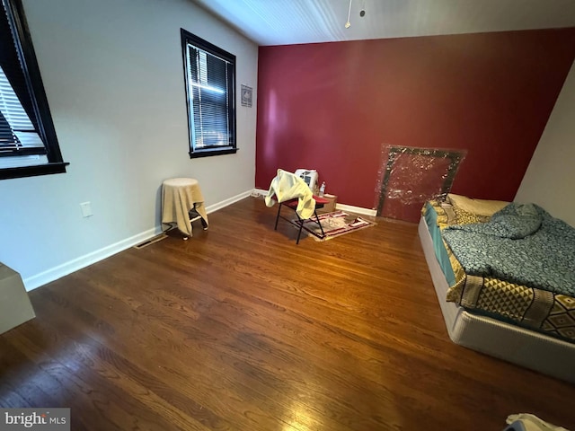 sitting room with dark hardwood / wood-style flooring and vaulted ceiling