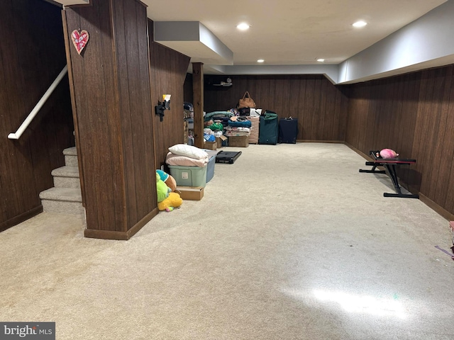 basement with light colored carpet and wooden walls