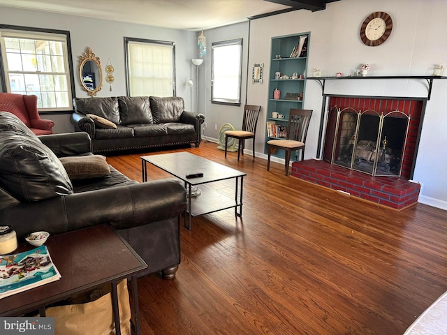 living room with wood-type flooring and a brick fireplace