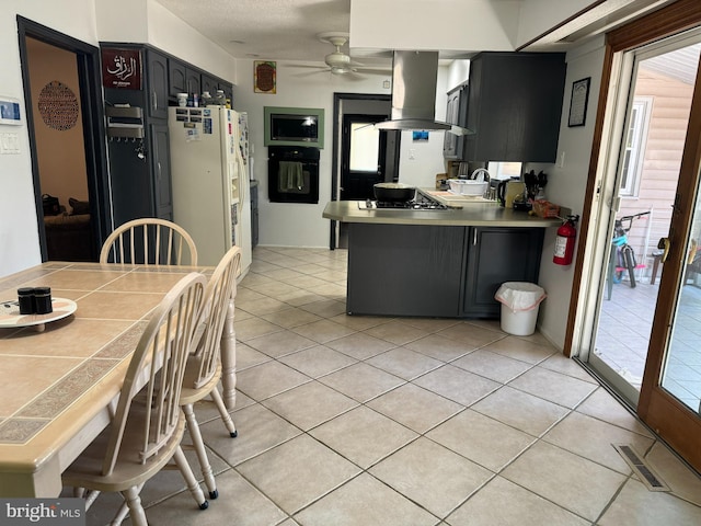 kitchen with island exhaust hood, black oven, white fridge with ice dispenser, kitchen peninsula, and ceiling fan