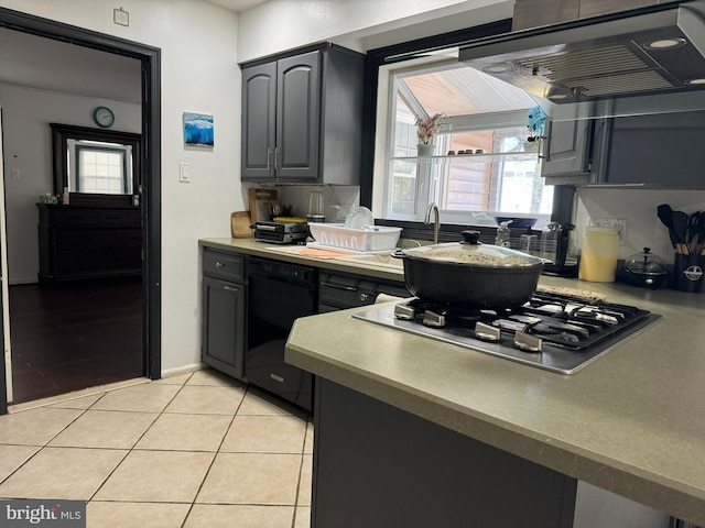 kitchen featuring light tile patterned flooring, extractor fan, black dishwasher, gray cabinets, and stainless steel gas cooktop