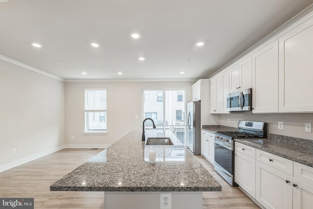 kitchen featuring light hardwood / wood-style floors, stone counters, a large island, crown molding, and appliances with stainless steel finishes