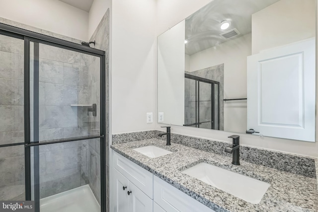 bathroom featuring a shower with shower door and vanity