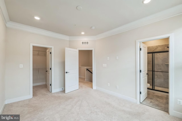 unfurnished bedroom with light colored carpet, connected bathroom, ornamental molding, a closet, and a spacious closet