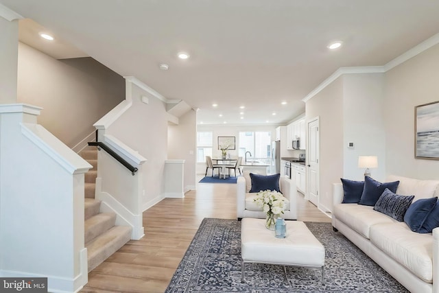 living room with light hardwood / wood-style floors and ornamental molding