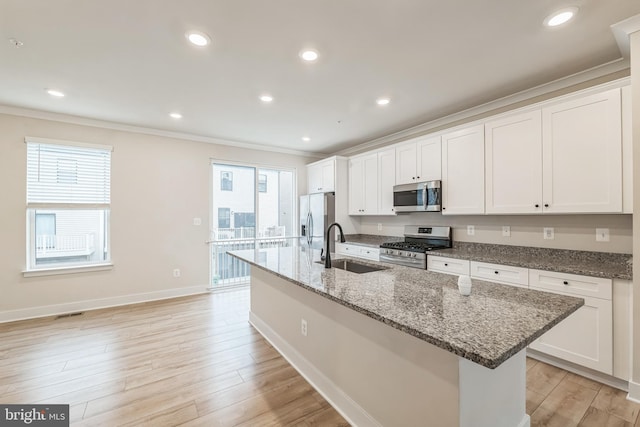 kitchen with a center island with sink, stainless steel appliances, a healthy amount of sunlight, and sink