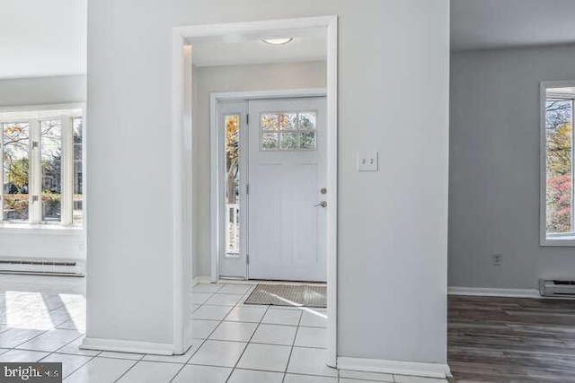 tiled entrance foyer with plenty of natural light and a baseboard heating unit