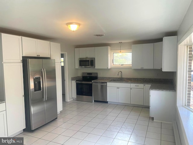 kitchen featuring stainless steel appliances, sink, a baseboard radiator, white cabinetry, and light tile patterned flooring