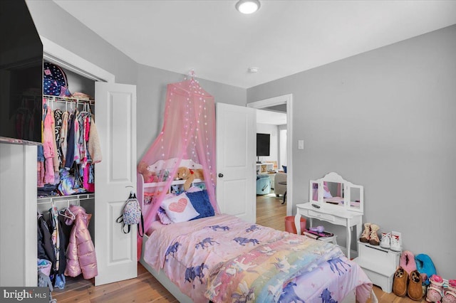 bedroom with a closet and hardwood / wood-style flooring