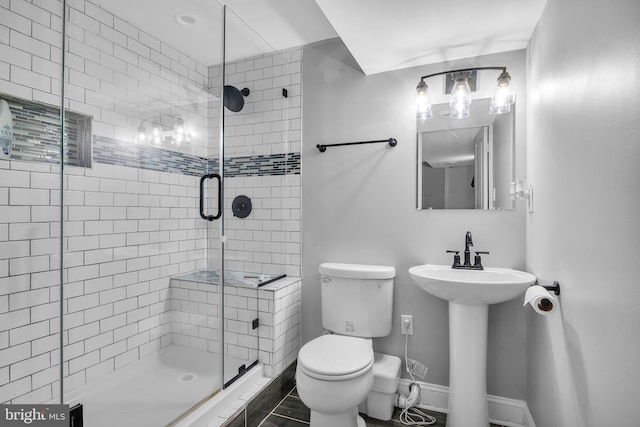 full bath with a shower stall, toilet, a sink, and baseboards