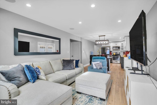 living room with light wood-type flooring and a notable chandelier