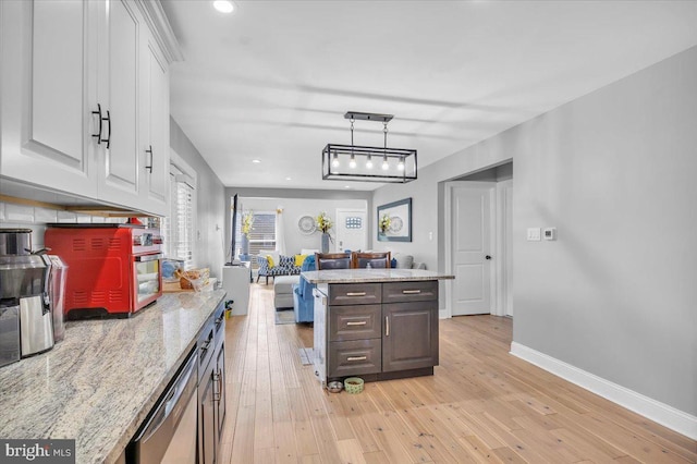 kitchen featuring light stone counters, dark brown cabinets, white cabinets, light wood-type flooring, and dishwasher