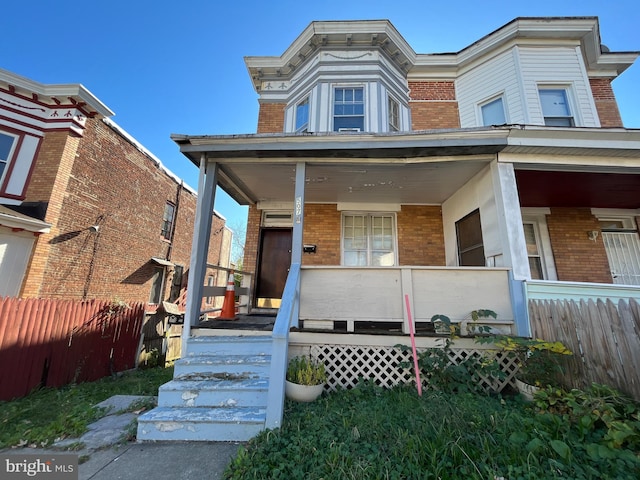 507 Richwood Ave, Baltimore, MD 21212 - view of front facade featuring brick siding, fence, and a porch