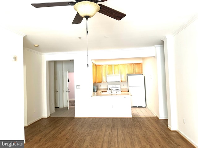 kitchen featuring kitchen peninsula, white appliances, hardwood / wood-style flooring, and ornamental molding