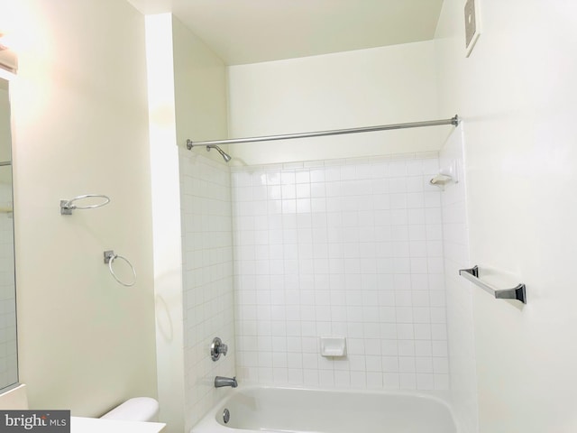 bathroom featuring tiled shower / bath combo and toilet