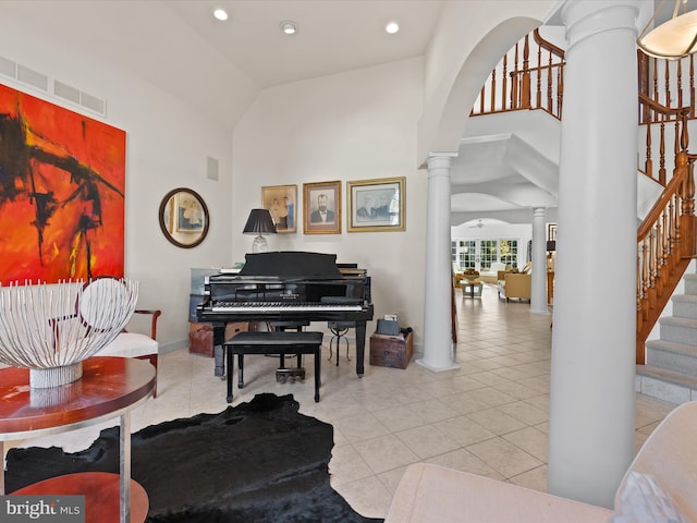 sitting room with high vaulted ceiling, decorative columns, and light tile patterned floors