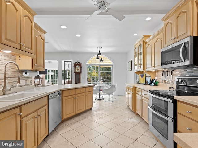 kitchen featuring stainless steel appliances, backsplash, light tile patterned floors, sink, and ceiling fan