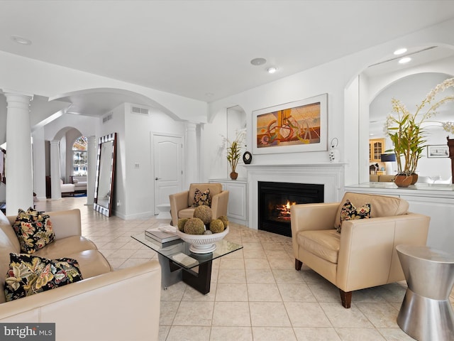 9 Glade Farm Dr, Rehoboth Beach, DE 19971 - living area featuring arched walkways, decorative columns, light tile patterned floors, a glass covered fireplace, and recessed lighting
