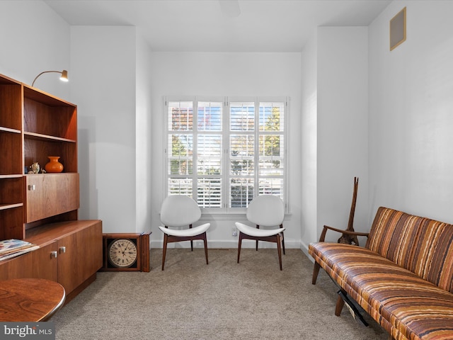 living area featuring light carpet