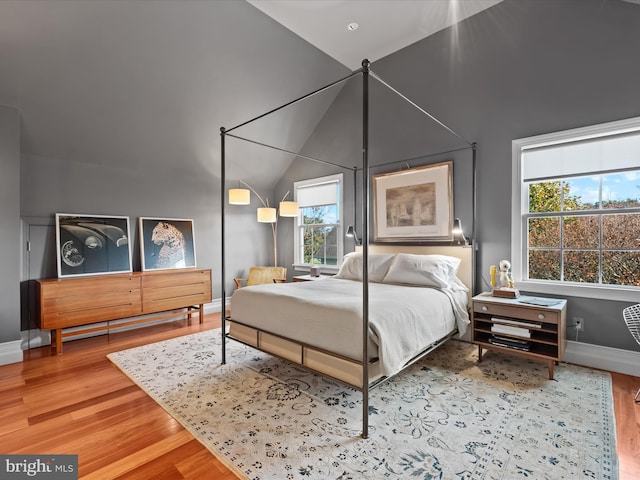 bedroom with hardwood / wood-style floors and vaulted ceiling