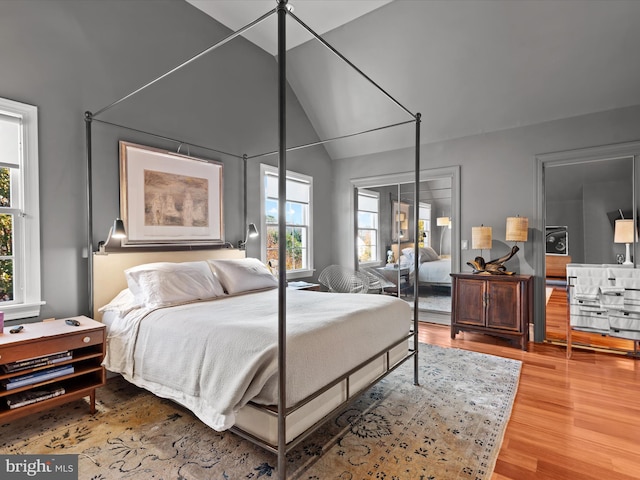 bedroom with wood-type flooring and vaulted ceiling