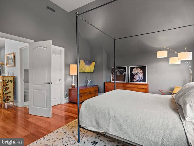 bedroom with hardwood / wood-style floors and vaulted ceiling