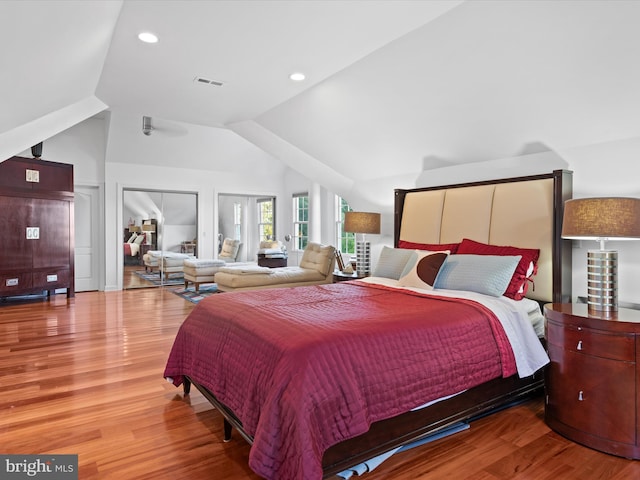 bedroom with hardwood / wood-style floors, a closet, and lofted ceiling