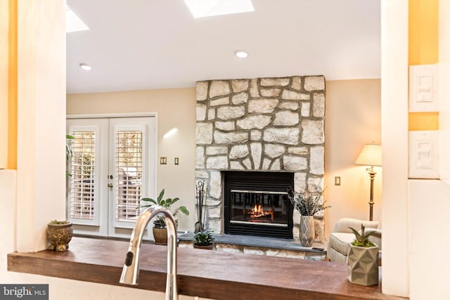 interior space featuring a stone fireplace, a skylight, and french doors