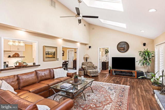 living room with high vaulted ceiling, dark wood-type flooring, ceiling fan, and a skylight