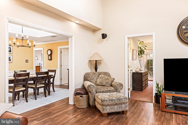 living room featuring dark hardwood / wood-style flooring, a chandelier, and ornamental molding