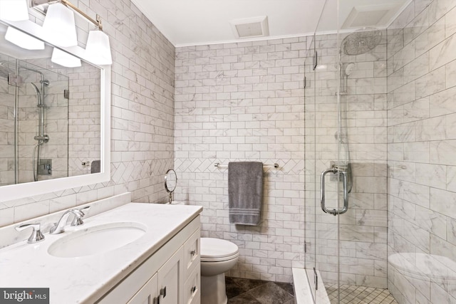 bathroom with walk in shower, vanity, tile walls, and toilet