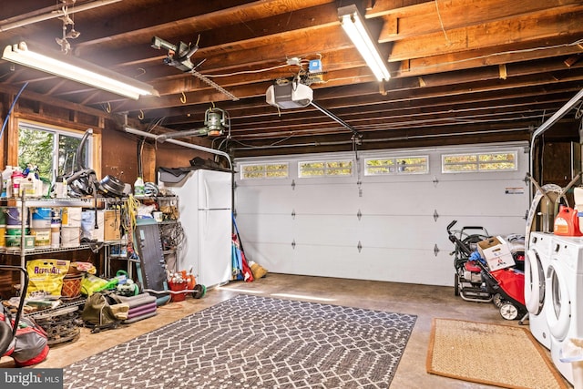 garage featuring washer and dryer, white refrigerator, and a garage door opener